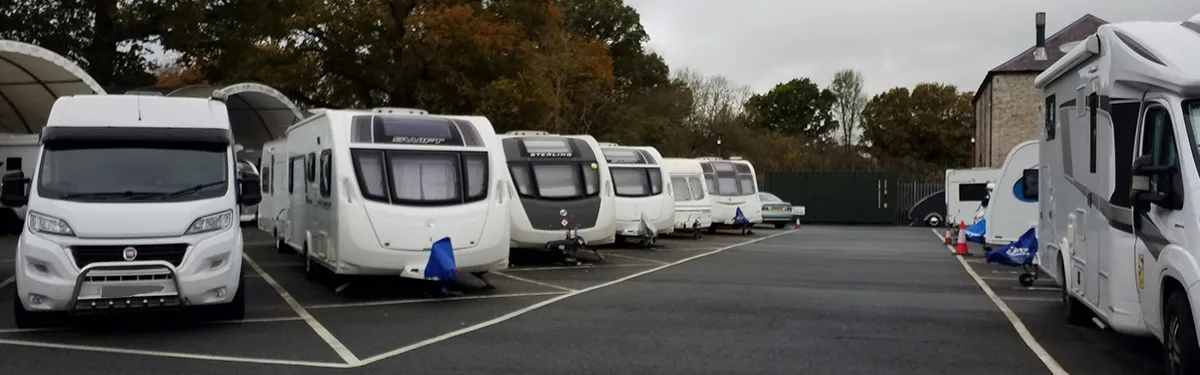 Caravans and motorhomes parked on numbered tarmac plots